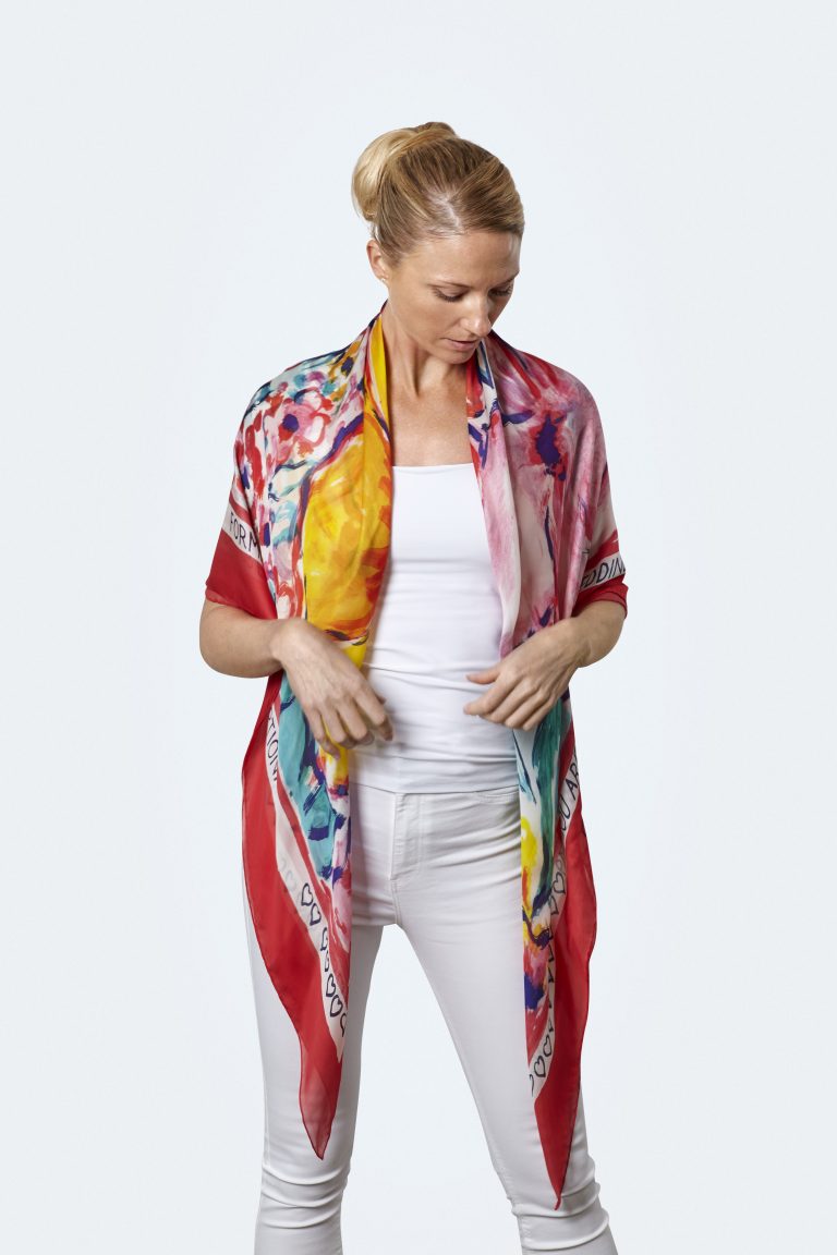 A personalized silk scarf with a red border, worn open