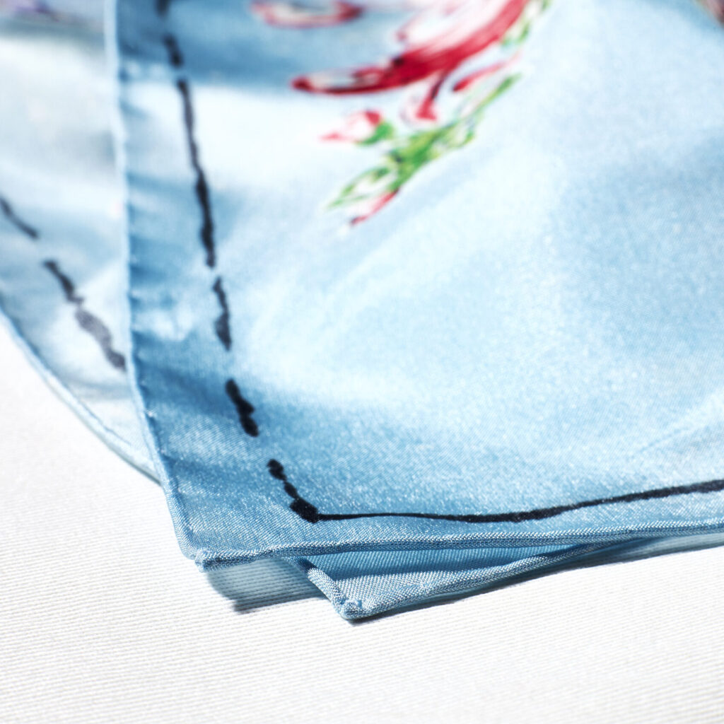The hand-rolled edge of a Lago di Como silk scarf