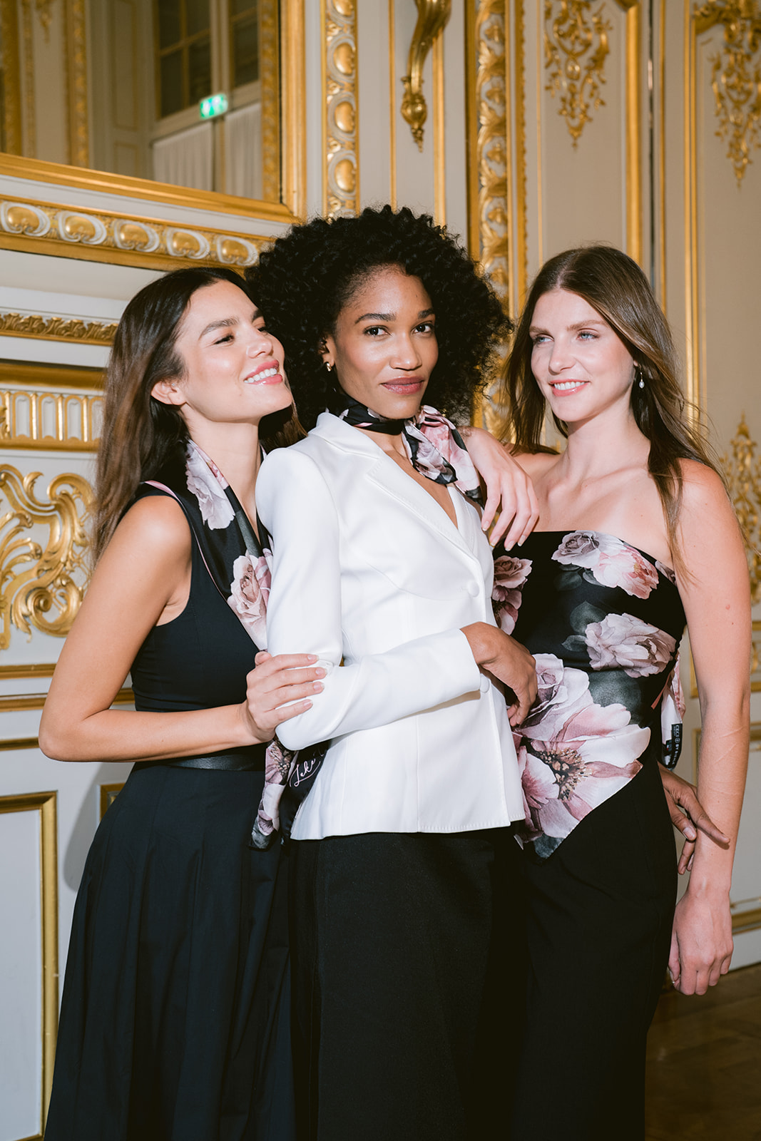 Three models in a gilded Paris salon wearing By Biehle silk scarves