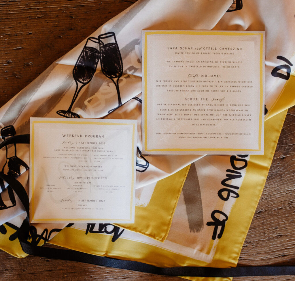 A wedding invitation suite lying on the custom silk scarf printed from the same artwork